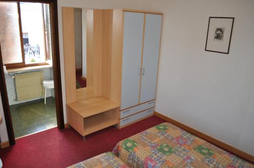 a bedroom with a closet and a bed and a cabinet at Hotel Piol in Limana