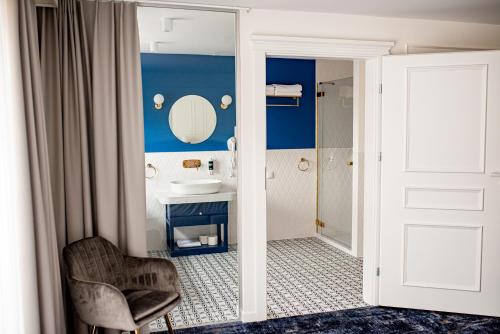 a bathroom with a sink and a mirror and a chair at Mały Sopot Boutique in Iława