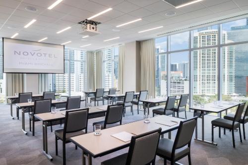 a conference room with tables and chairs and a projection screen at Novotel Miami Brickell in Miami