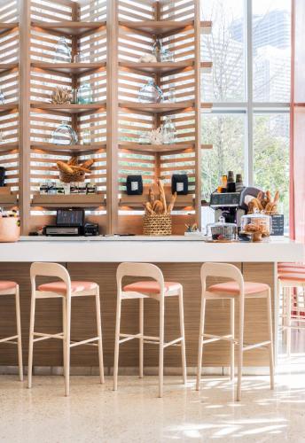 a kitchen with four stools in front of a counter at Novotel Miami Brickell in Miami