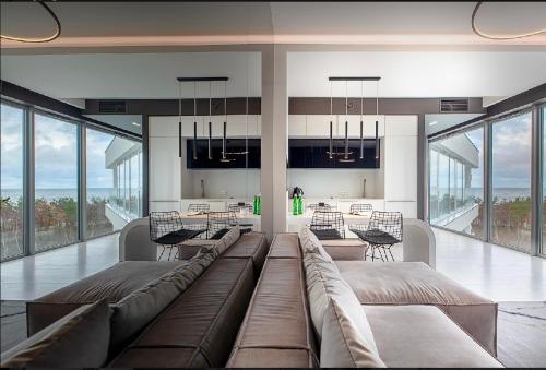 ein Wohnzimmer mit einem großen Sofa und einem Tisch in der Unterkunft Dune Beach Luxury Suites in Mielno