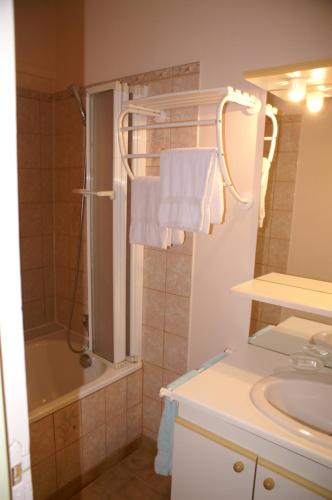 a bathroom with a sink and a shower with towels at Gites de la Filaterie in Cormatin