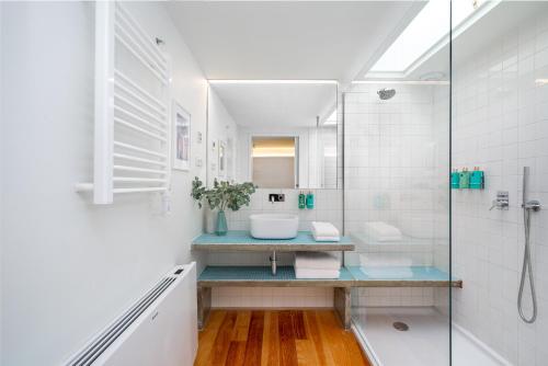 a white bathroom with a sink and a shower at Villa Almada - Amazing City Centre Villa with Private Pool in Porto