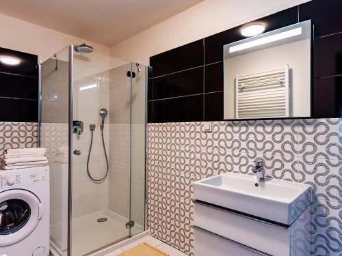 uma casa de banho com um lavatório e uma máquina de lavar roupa em VacationClub – 5 Mórz Sianożęty Apartament 1K/1 em Sianozety