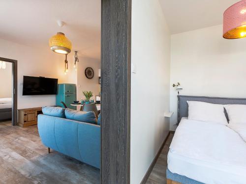 um quarto com uma cama e um sofá azul em VacationClub – 5 Mórz Sianożęty Apartament 1K/1 em Sianozety