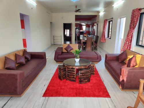 a living room with couches and a red rug at Quinte Hills Residency in Panchgani