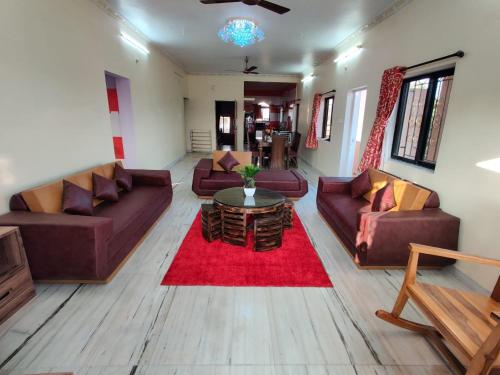 a living room with couches and a red rug at Quinte Hills Residency in Panchgani