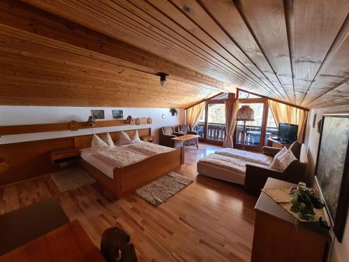 a large room with two beds and a couch at Alpenpension Bergidyll in Schönau am Königssee