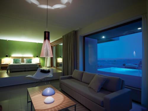 a living room with a couch and a bed and a table at Thalatta Seaside Hotel in Ayia anna