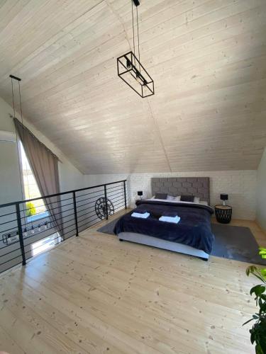 a bedroom with a bed on a wooden floor at ŚNIEŻKA HOUSE in Mysłakowice