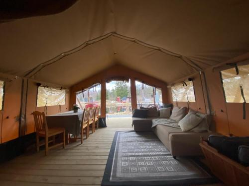 a tent with a couch and a table and chairs at Norrängens Alpacka - Det lilla boutiquehotellet med en fluffy twist ! in Sala