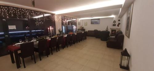 a dining room with a long table and chairs at Vila La Faleza Dubova in Dubova