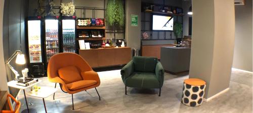 uma loja com duas cadeiras e uma cadeira verde em Best Guest Hotel Expo Anhembi em São Paulo