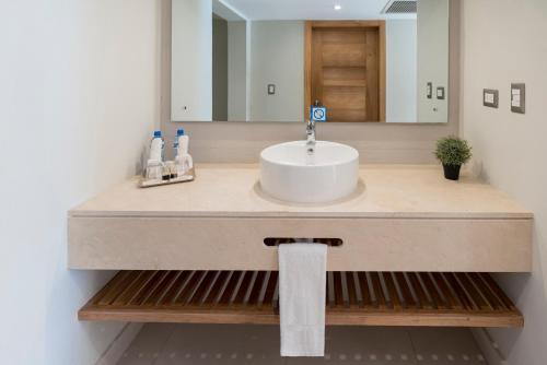 a bathroom with a sink and a mirror at Casa Marina Beach & Reef All Inclusive in Sosúa