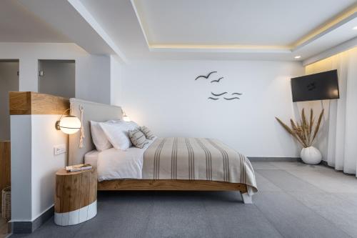 a bedroom with a bed in a white room at NISSEA Boutique Hotel in Kardamaina