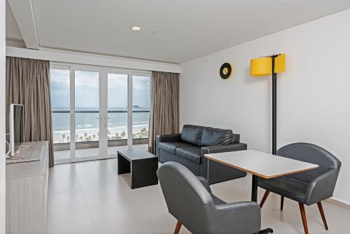 a living room with a couch and a table at Guarujá Vivah in Guarujá