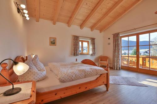 a bedroom with a bed and a large window at Ferienhaus Zechmeister in Schönau am Königssee