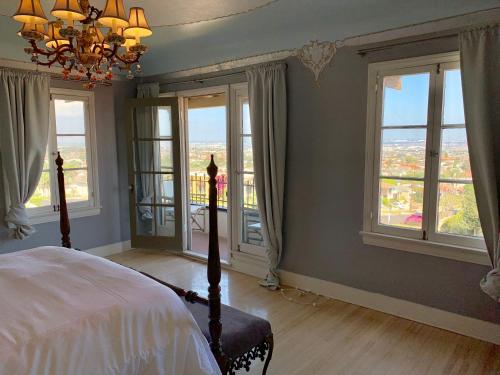 a bedroom with a bed with windows and a chandelier at SpanishFairytale4bd3ba in San Pedro