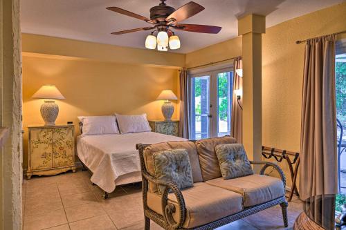 a bedroom with a bed and a couch and a ceiling fan at Lido Key Hideout with Patio and Yard and Walk to Beach! in Sarasota