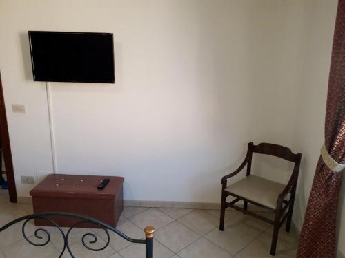 a living room with a chair and a tv at Tahiti House Stagnone in Marsala