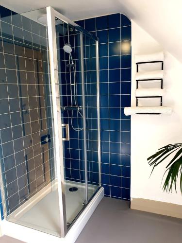 a shower in a bathroom with blue tiles at Time & Tide Town House in Seaford