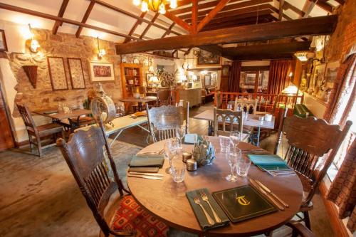 uma sala de jantar com uma mesa de madeira e cadeiras em The Tankerville Arms em Eglingham
