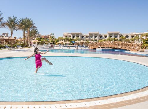 a young girl jumping into a pool at a resort at Serenity Alma Heights - Ex Serenity Fun City in Hurghada
