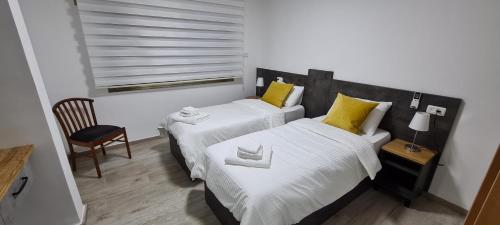a bedroom with two beds with yellow and white pillows at Maria's GuestHouse - Uphill View of Nazareth F in Nazareth