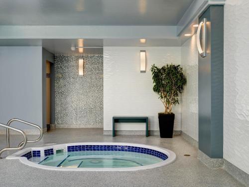 a hot tub in a lobby with a bench and a plant at Chateau Victoria Hotel & Suites in Victoria