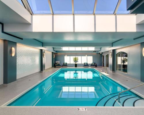 an indoor swimming pool with a large glass ceiling at Chateau Victoria Hotel & Suites in Victoria