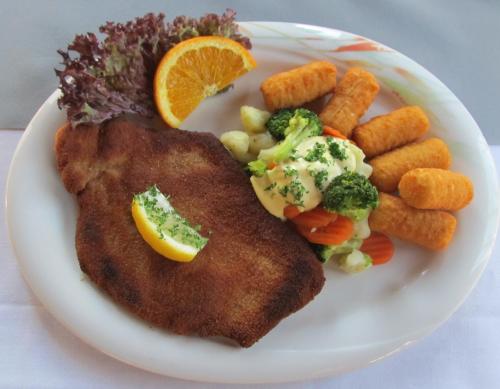 a plate of food with fish and vegetables and carrots at Hotel-Klanxbüller-Stuben in Neukirchen