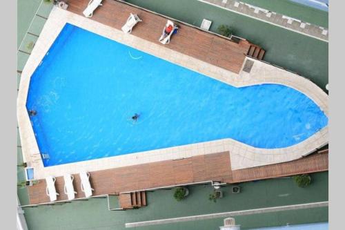 an overhead view of a large swimming pool with people sitting around it at Cabo Corrientes - Mar del Plata - Preguntar antes de reservar in Mar del Plata