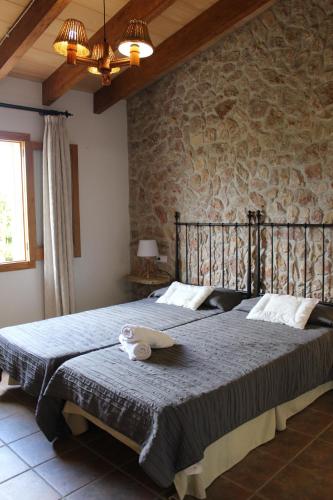 um quarto com uma cama grande e uma parede de pedra em finca son gallina con piscina y jardín en Sa Pobla, ideal para 6 personas em La Puebla