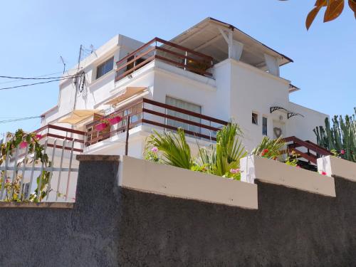 a white house with flowers on the balcony at Casa Doramas VV in Las Palmas de Gran Canaria
