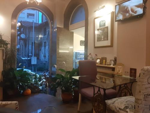 a living room with a table and a window at Pop Bogomil family hotel in Sofia