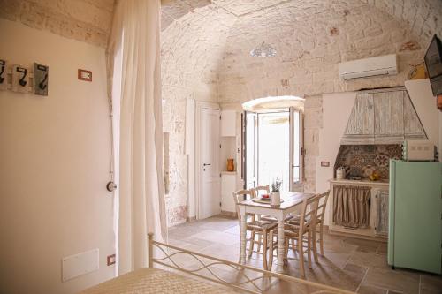 - une cuisine et une salle à manger avec une table et des chaises dans l'établissement Domus Petra 104, à Ceglie Messapica