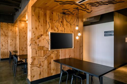 a room with a table and a tv on a wall at Kinship Landing in Colorado Springs