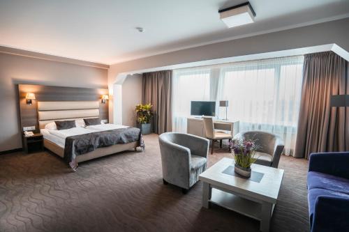 Habitación de hotel con cama y sala de estar. en Bellevue Park Hotel Riga with FREE Parking, en Riga