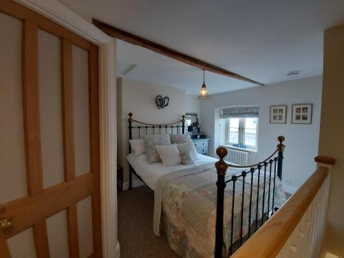 a bedroom with a bed with white pillows at St Etheldreda's Cottage, Wells, Somerset in Wells