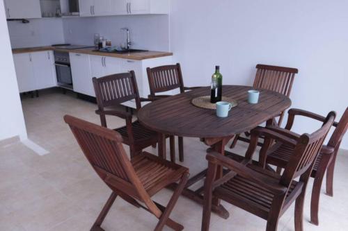 a wooden table with chairs and a bottle of wine at Costa Brava apartment with stunning sea view in Llança