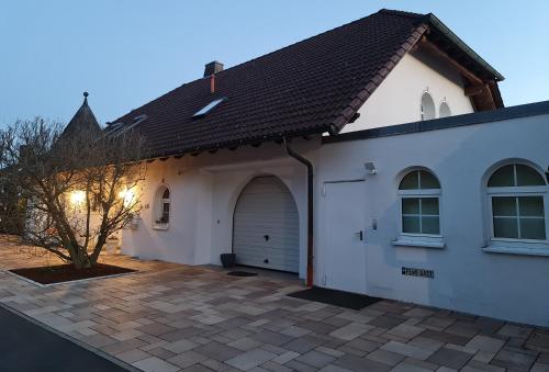 a white house with a garage at GardenView Apartments & Suites bei Bad Kissingen in Nüdlingen