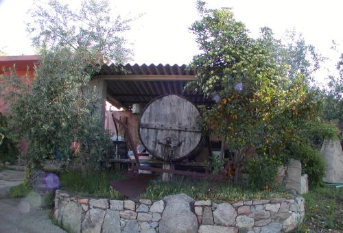 a small house with a barrel in the yard at Agriturismo Su Barraccu in Loceri