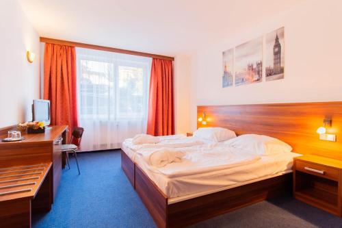 a hotel room with a large bed and a desk at LIPNO WELLNESS - FRYMBURK C112 private family room in Frymburk