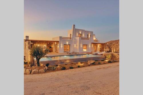 a house in the desert with a swimming pool at Blue Orchid Villa Mykonos in Kalafatis