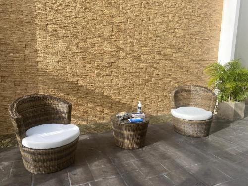 three wicker chairs and a table on a patio at Quinta Santa Anita in Playa del Carmen