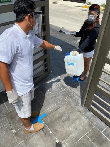 a man wearing a mask and gloves opening a door at Quinta Santa Anita in Playa del Carmen