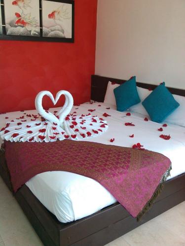 a bed with two white swans and roses on it at Quinta Santa Anita in Playa del Carmen