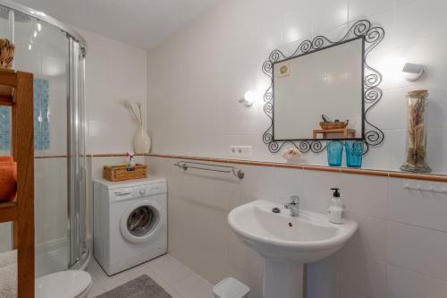 a bathroom with a sink and a washing machine at Mi Casa in Caleta De Velez