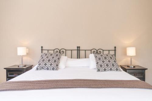 a bedroom with a large white bed with two lamps at Casa De La O in San Miguel de Allende