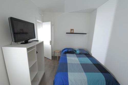 - une petite chambre avec une télévision et un lit dans l'établissement Appartement - Cosy T1 bis, proche de Paris, à Villeneuve-la-Garenne